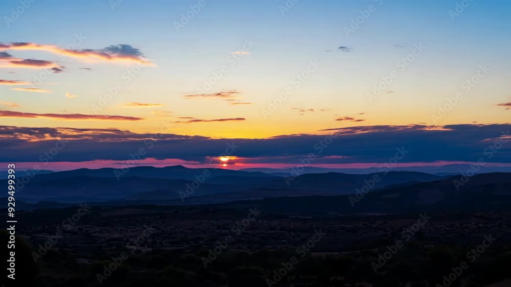 Evening Splendor: Sun Setting Behind Mountain Peaks with Majestic Cloud Patterns Evening Splendor: Sun Setting Behind Mountain Peaks with Majestic Cloud Patterns