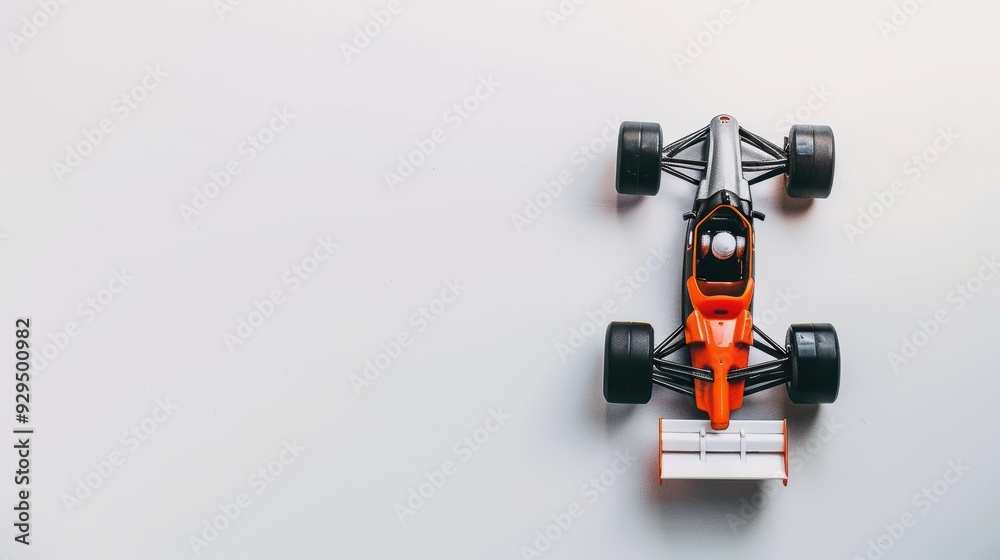 Black and orange toy race car displayed on a white background with empty space to the side Black and orange toy race car displayed on a white background with empty space to the side