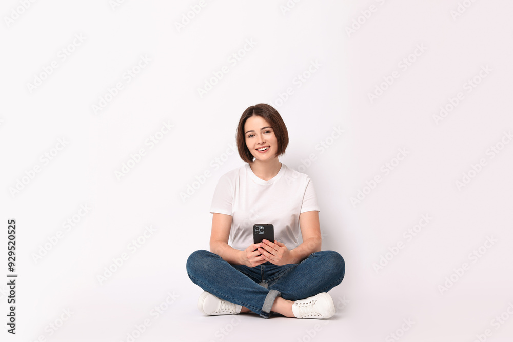 Smiling woman with smartphone sitting on white background Smiling woman with smartphone sitting on white background