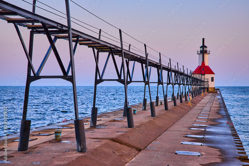 Obraz premium Benton Harbor Lighthouse at Sunrise Along Concrete Pier