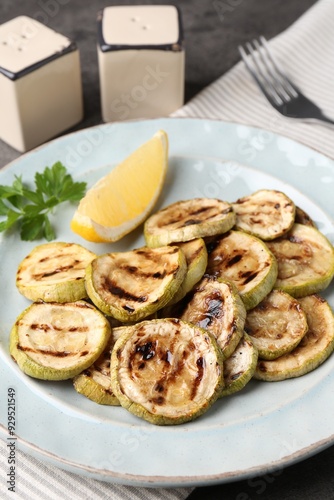 Tasty grilled zucchini slices served on grey table