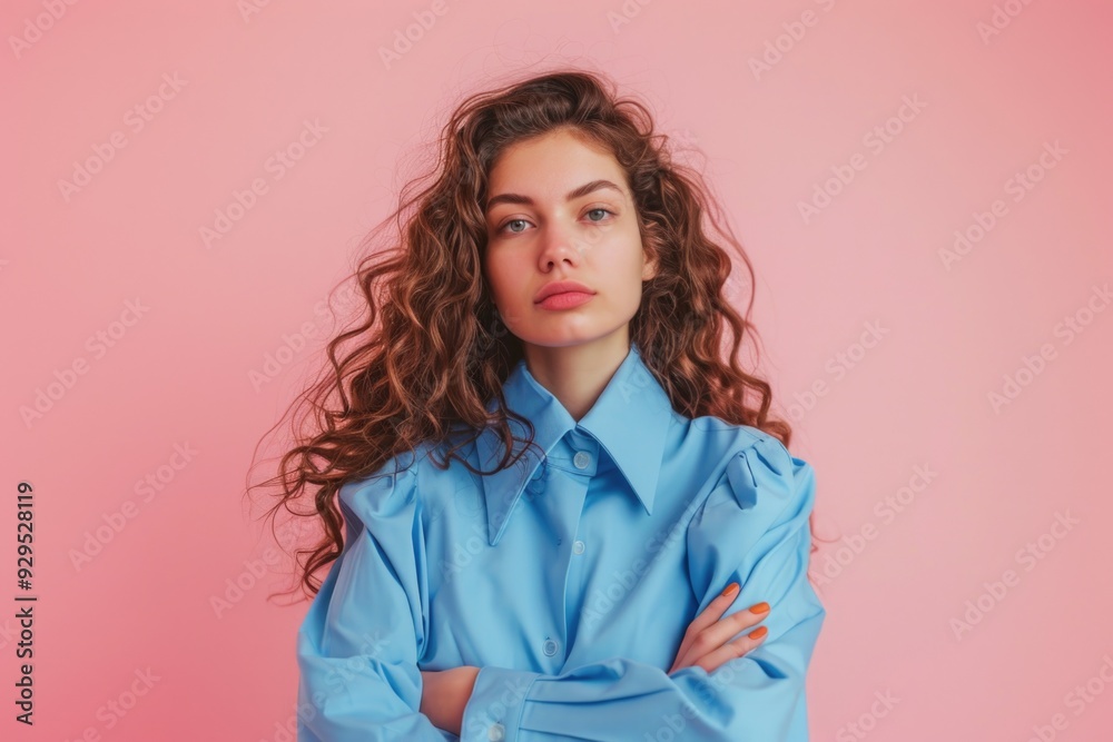 A woman with curly hair and a blue shirt, posing in a casual setting A woman with curly hair and a blue shirt, posing in a casual setting