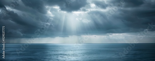 Sunbeams Shining Through Storm Clouds Over Calm Ocean