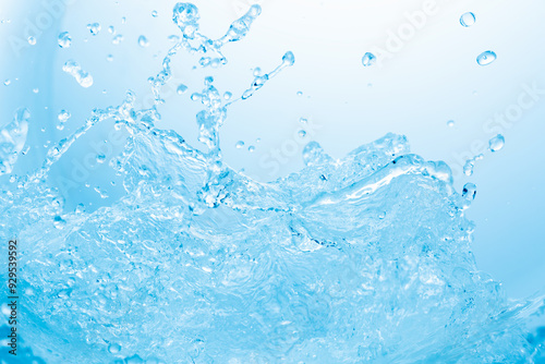 青の背景に波のように舞う水しぶき.