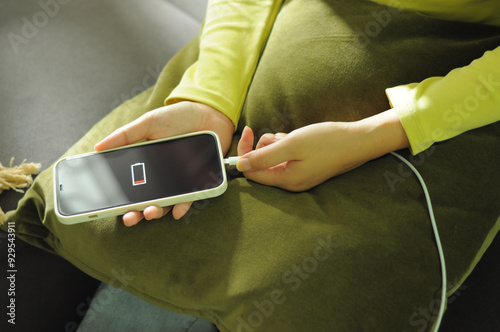 Charging mobile phone battery with wireless charging device in the table. Smartphone charging on a charging pad. Mobile phone near wireless charging