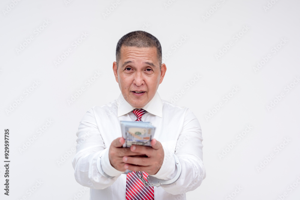 A middle aged professional or manager under arrest and in handcuffs, holding cash trying to bribe his way into freedom. Possible bail money. Isolated on a white background. A middle aged professional or manager under arrest and in handcuffs, holding cash trying to bribe his way into freedom. Possible bail money. Isolated on a white background.