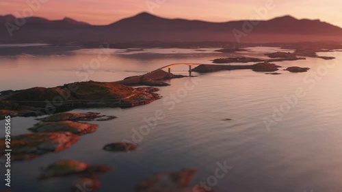 Narrow bridges of Atlantic road span between the small rocky islands. Aerial view. photo