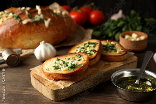 Garlic bread, vegetables and butter on wooden background, close up