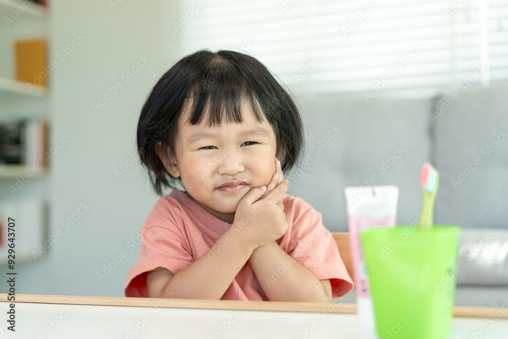 little asian girl presses hand to cheek, suffers from pain in tooth. Teeth decay, dental problems, child emotions and facial expression, oral health care, reducing sweets, fluorine coating little asian girl presses hand to cheek, suffers from pain in tooth. Teeth decay, dental problems, child emotions and facial expression, oral health care, reducing sweets, fluorine coating