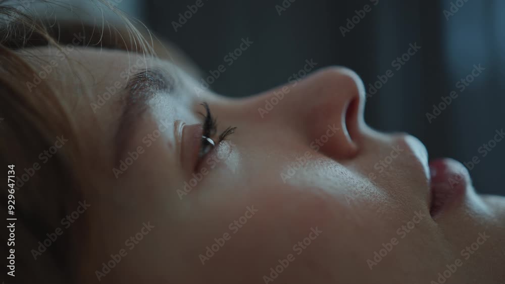 Young depressed woman lying in bed at home, opening her eyes and staring up emotionlessly. Close-up view Young depressed woman lying in bed at home, opening her eyes and staring up emotionlessly. Close-up view