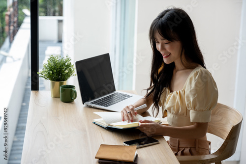 Asian woman working with notebook in modern coffee shop