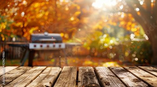 A wooden table in autumn with a grill and colorful foliage in the background.