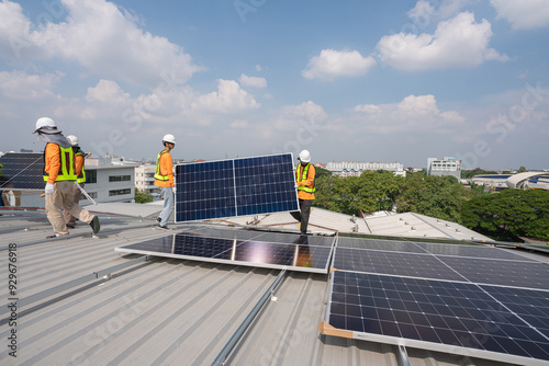 Men technicians carrying photovoltaic solar moduls on roof of factory on the morning. Installing a Solar Cell on a Roof. Solar panels on roof. Workers installing solar cell power plant eco technology. photo