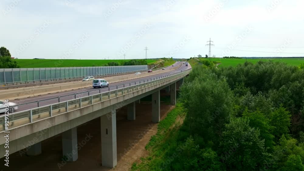 Vehicles Speeding On Highway Bridge Through Vegetation. Autobahn Traffic. drone shot Vehicles Speeding On Highway Bridge Through Vegetation. Autobahn Traffic. drone shot