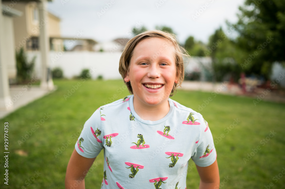 Teen boy smiling at camera in a suburban backyard Teen boy smiling at camera in a suburban backyard