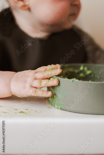 Close up of weaning baby hand messy from food