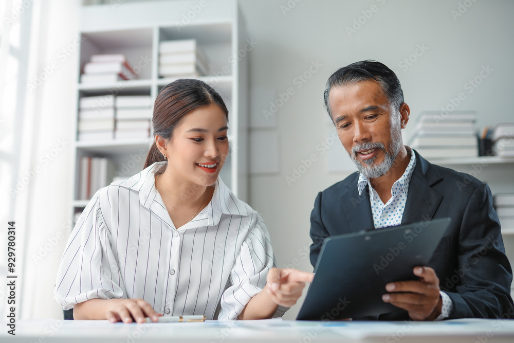 Businessman holding a clipboard and explaining business strategy to his colleague during a meeting Businessman holding a clipboard and explaining business strategy to his colleague during a meeting
