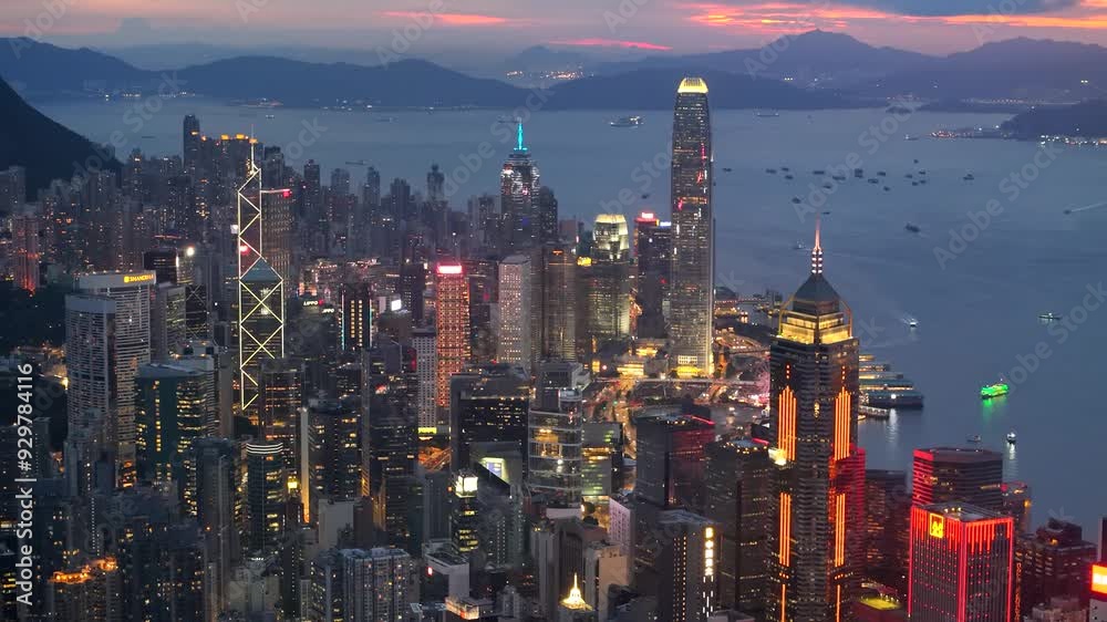 Aerial view drone video City landscape of the famous travel landmark cityscape. buildings with light and transportation at Victoria Harbour skyline and Kowloon at sunset along Hong Kong Island China.