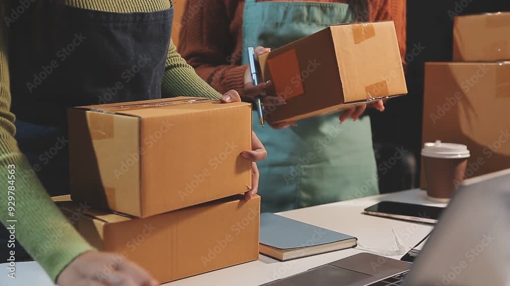 Startup SME small business entrepreneur of freelance Asian woman wearing apron using laptop and box to receive and review orders online to prepare to pack sell to customers, online sme business ideas.
