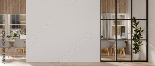 Fototapeta Naklejka Na Ścianę i Meble -  A hallway features an empty white wall and a glass partition that looks into a meeting room.