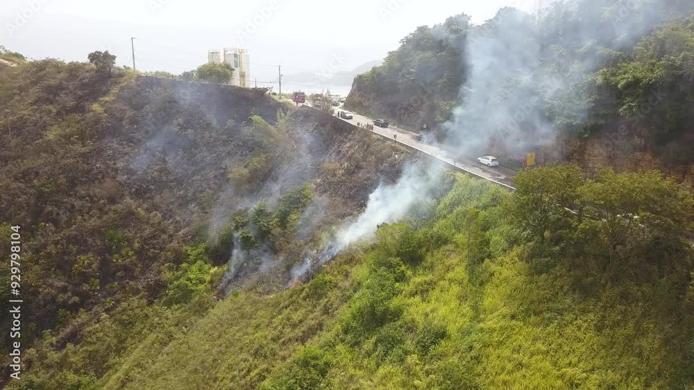 Mountain fire near road with traffic. Aerial flying forward Mountain fire near road with traffic. Aerial flying forward