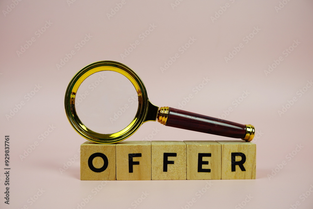Offer with wooden blocks alphabet letters and Magnifying glass on pink background Offer with wooden blocks alphabet letters and Magnifying glass on pink background