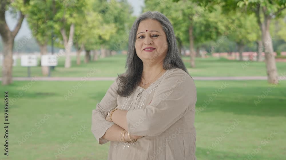 Portrait of Happy Indian old woman standing crossed hands in park Portrait of Happy Indian old woman standing crossed hands in park