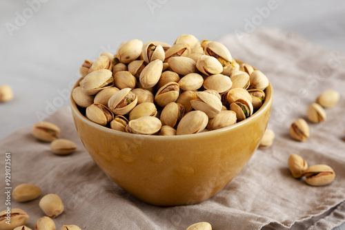 Roasted and Salted Pistachios in a Bowl on a gray background, side view.