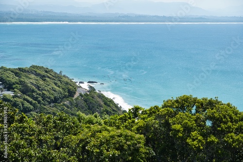 Clear lines of waves in perfectly clear water. Surfers in the water in front of Wategos Beach, Byron Bay, Australia. Most Easterly Point of the Australian Mainland. Surfer's paradise spot.  photo