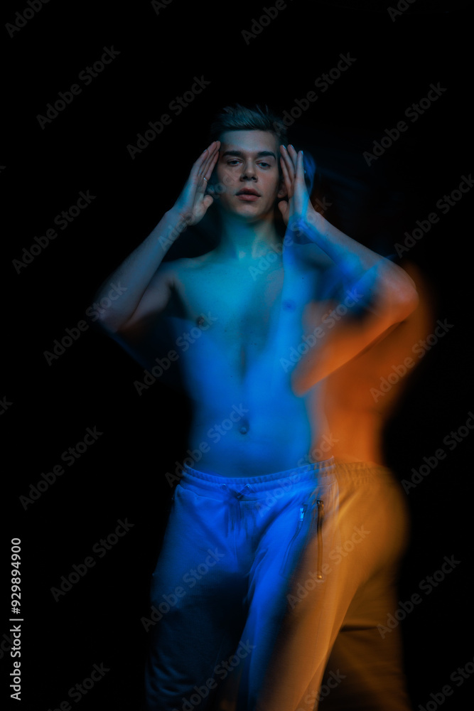 blurred silhouette, young man posing in the dark with red and blue light in the studio blurred silhouette, young man posing in the dark with red and blue light in the studio