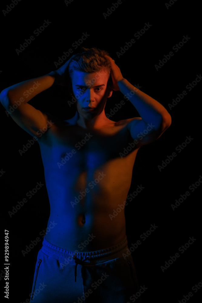 blurred silhouette, young man posing in the dark with red and blue light in the studio blurred silhouette, young man posing in the dark with red and blue light in the studio