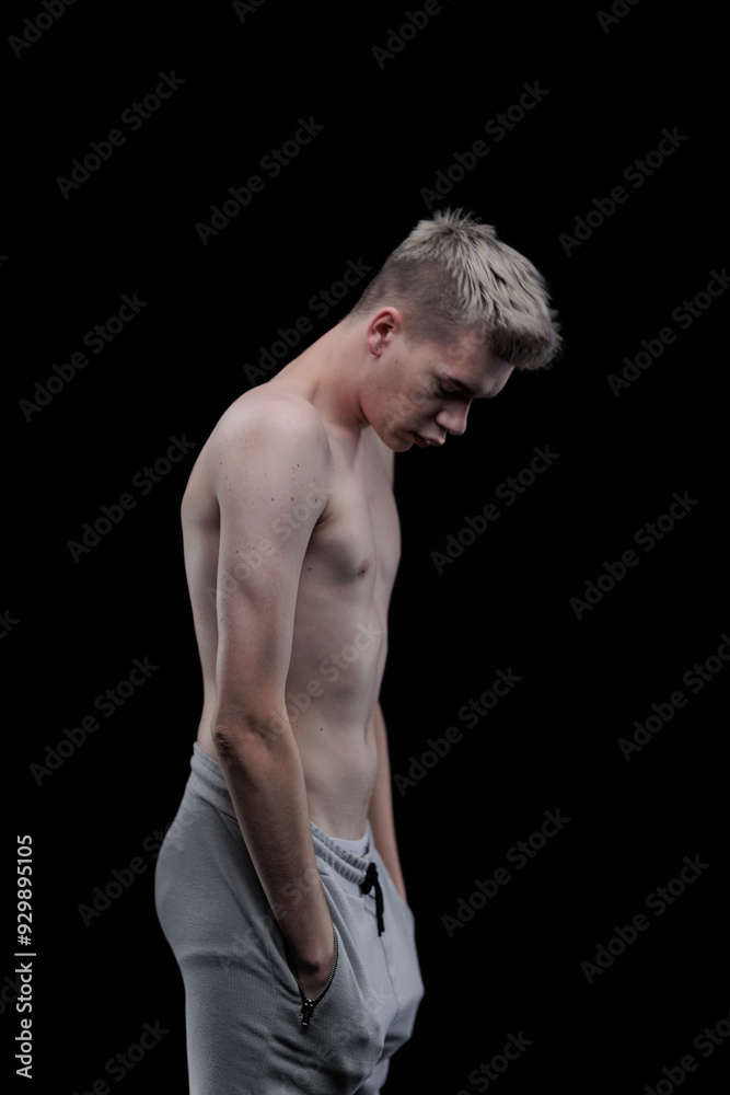 Fototapeta premium Young man posing in the dark in the studio