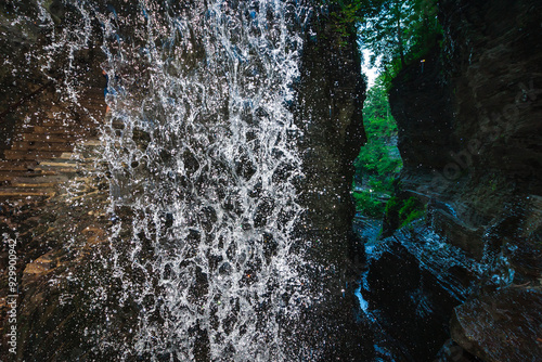 A waterfall falls into a pool among rock formations at Watkins Glen State Park in Pennsylvania, showcasing the power and beauty of nature, USA photo