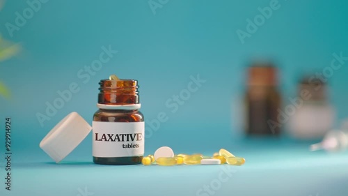 HAND TAKING OUT LAXATIVE TABLETS FROM MEDICINE BOTTLE