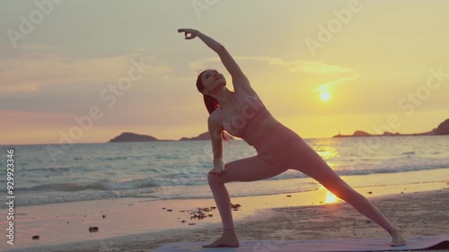 Young Asian woman practicing yoga pose on the beach at sunset.concept for Yoga Sport and Healthy lifestyle