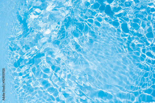 Blue water with ripples on the surface. Defocus blurred transparent blue colored clear calm water surface texture with splashes and bubbles. Water waves with shining pattern texture background.