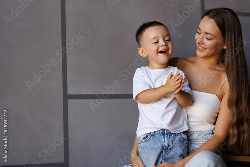 Mom hugging her son sit on stairs at home and have fun photo