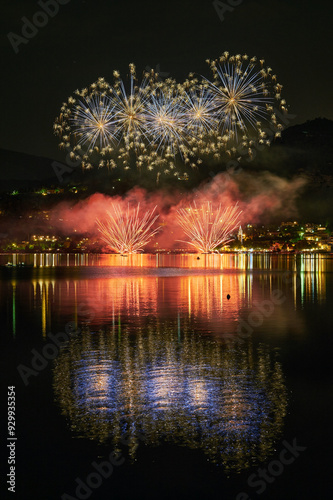 I fuochi d'artificio del lago di Pusiano, spettacolari forme di luce nel cielo che si riflesttono nelle acque del lago. Sullo sfondo, il paesaggio urbano illuminato photo