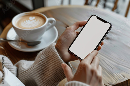 Close up of black cell phone held by woman's hands in cafe