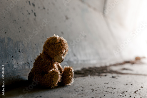 Homeless poor teddy bear in a dark tunnel. Homelessness, poverty, depression concept. Light in the end of the tunnel