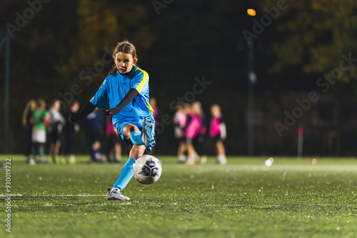 teenage girl soccer player practicing with football ball, Young sportive girl training in blue uniform. High quality photo