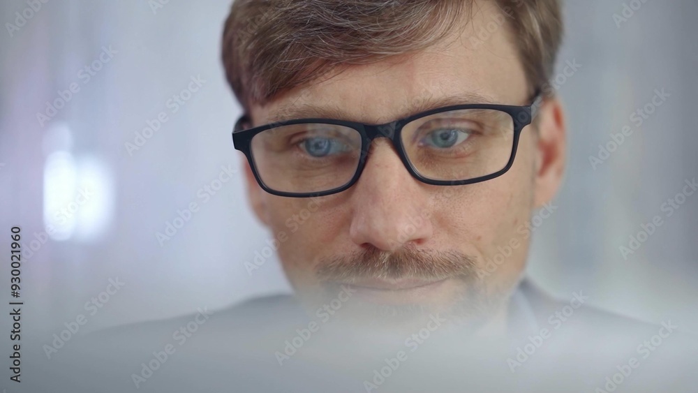 Businessman with glasses looking intently obscured partially by a translucent surface of laptop. Business people concept Businessman with glasses looking intently obscured partially by a translucent surface of laptop. Business people concept