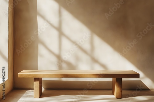 A minimalist wooden bench against a beige wall with delicate shadows of leaves and branches, creates a serene atmosphere for product photography