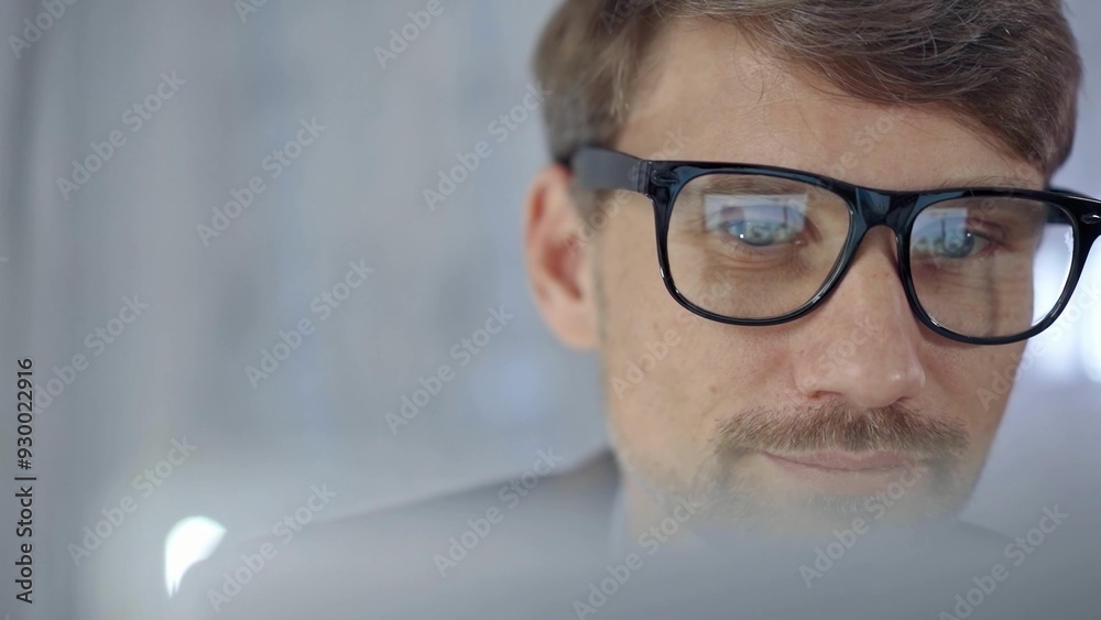Businessman with glasses looking intently obscured partially by a translucent surface of laptop. Business people concept