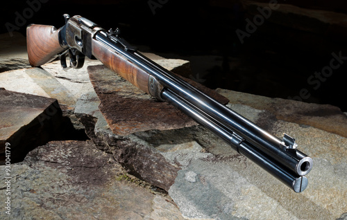 Obraz na płótnie Lever action rifle on stone with a dark background w salonie