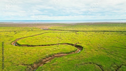 Cracked mud flats in a salt marsh. Aerial: Tidal mudflats, Abstract textures in a cracked coastline, Salt marshes at low tide exposing mud flats and streams at Freiston Shore Lincolnshire UK photo