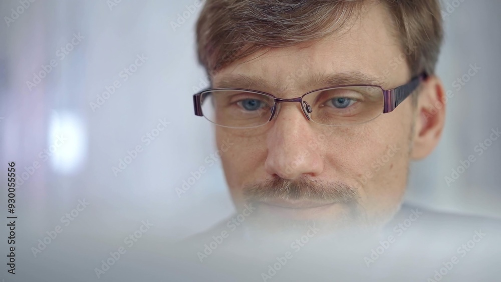 Businessman with glasses looking intently obscured partially by a translucent surface of laptop. Business people concept Businessman with glasses looking intently obscured partially by a translucent surface of laptop. Business people concept