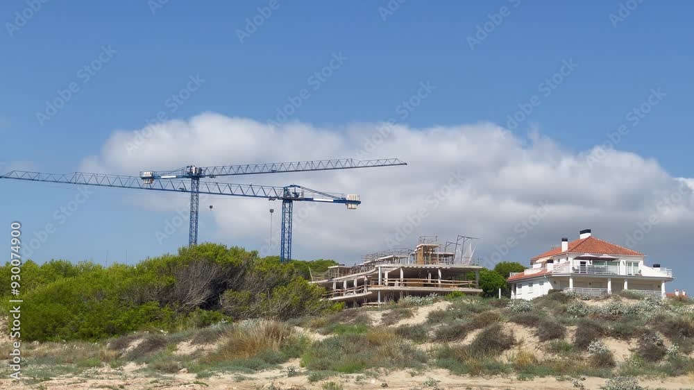 Cranes working against the background of the blue sky. Construction of apartments on the seashore. High quality 4k footage Cranes working against the background of the blue sky. Construction of apartments on the seashore. High quality 4k footage