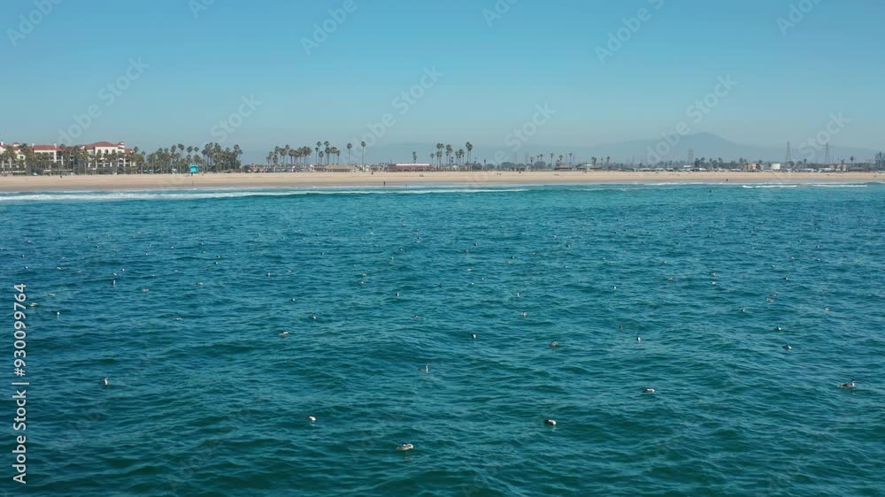 Flying above the water, towards the beach in HB then ascending to reveal city Flying above the water, towards the beach in HB then ascending to reveal city