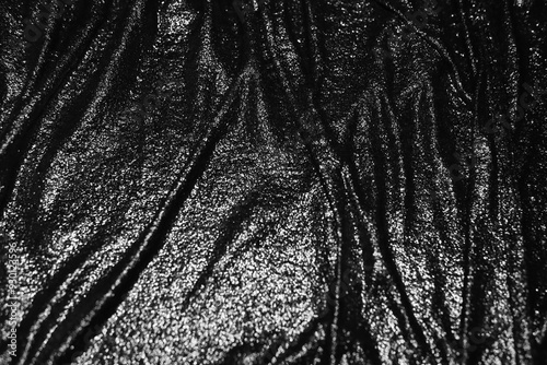 Defocused black background with wavy texture. Wet black cloth texture	